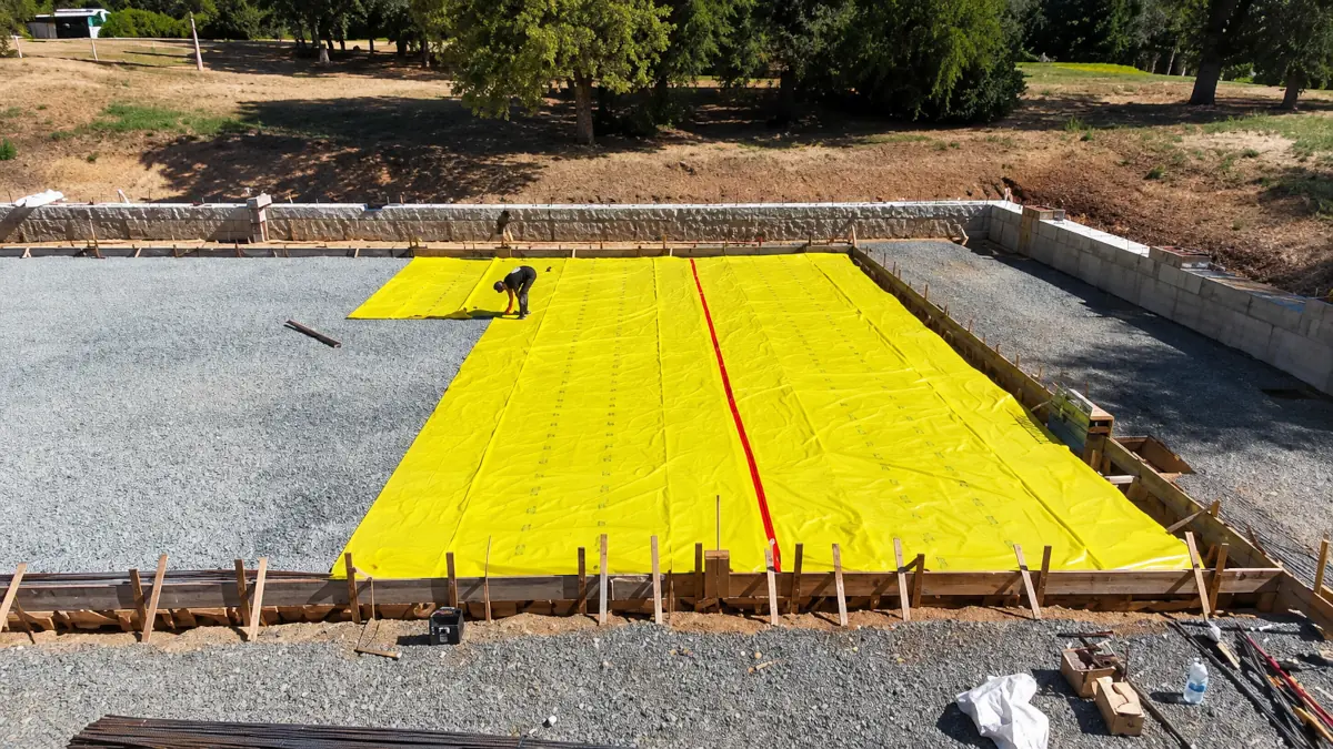 Vapor barrier and gravel base prepped before a concrete pour